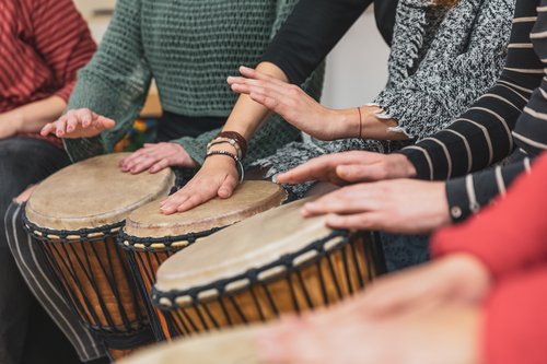 Group of people playing drums during a music therapy lessons, jembe drum, drumming concept Personen trommeln.