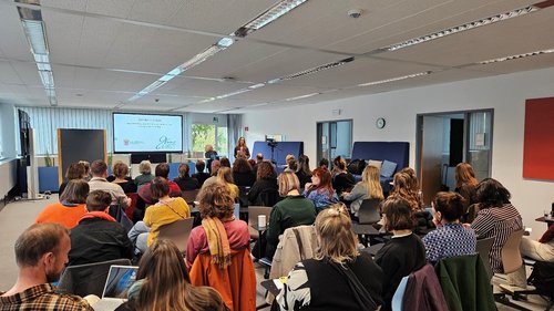 Personen folgen einem Vortrag